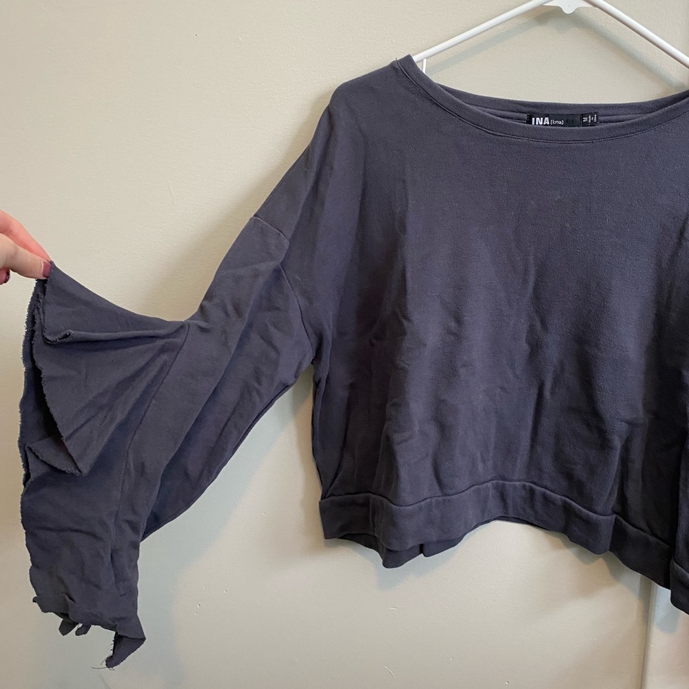 Cropped gray sweatshirt with ruffled sleeves.